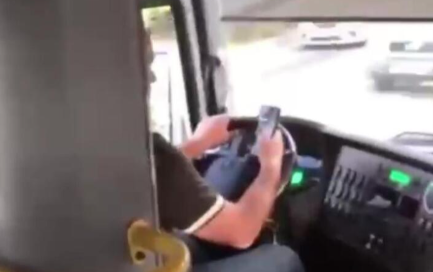 Водитель маршрутки с телефоном за рулем