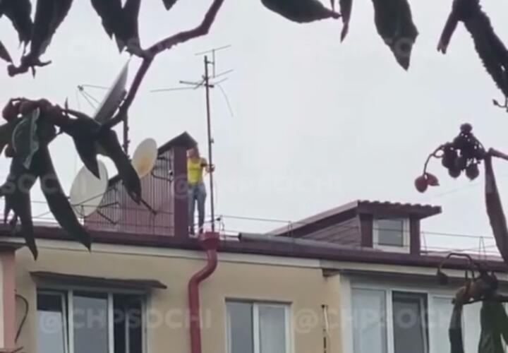 В Сочи неизвестная забралась на крышу и пыталась сломать антенну ВИДЕО