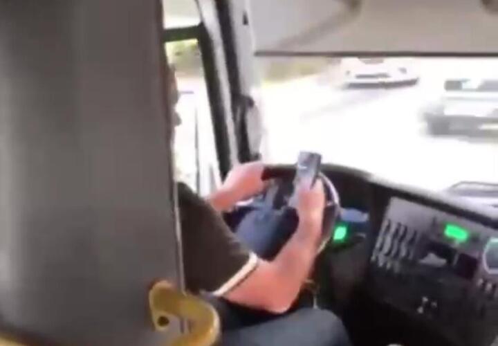 Водитель разговаривал по телефону за рулем, держа его в руках во время движения