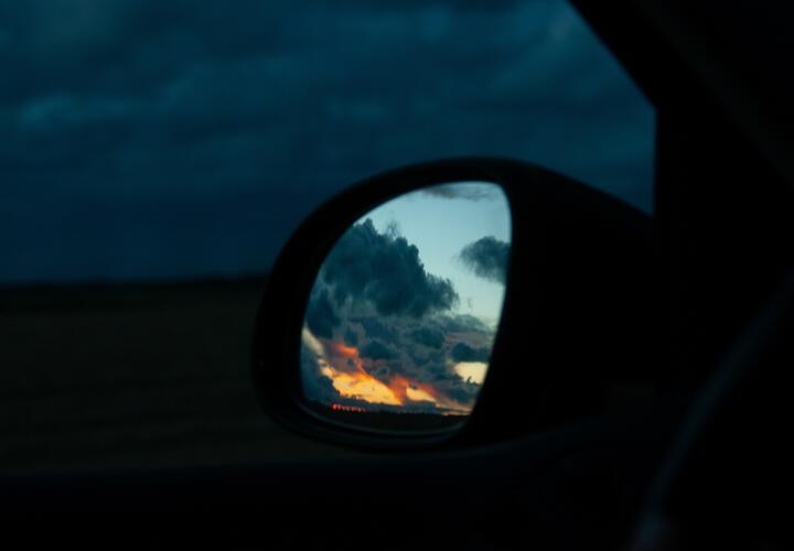 Отражение заката в боковом зеркале автомобиля