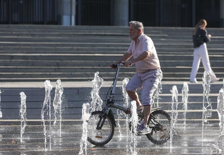 Велосипедист на фоне фонтана