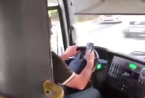 Водитель разговаривал по телефону за рулем, держа его в руках во время движения