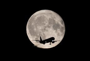 Самолет на фоне луны