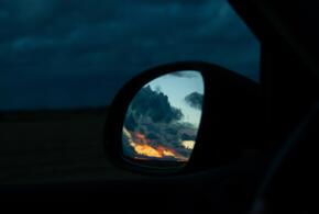 Отражение заката в боковом зеркале автомобиля